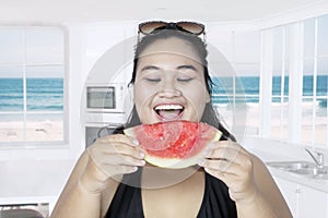 Obese woman eating fresh watermelon