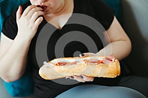 Obese woman eating huge portion of unhealthy food