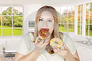 Obese woman eats two donuts at home