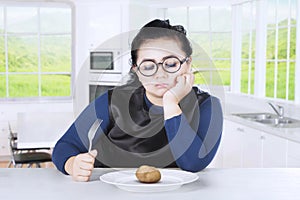 Obese woman feeling bored with potato
