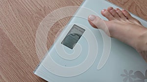 Obese woman getting on scales for weight control during healthy diet, weightloss