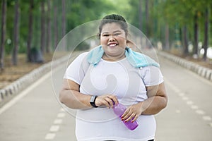 Obese woman holding a bottle on the road