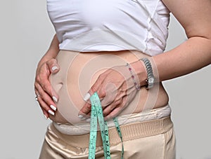 Obese woman holding a centimeter tape