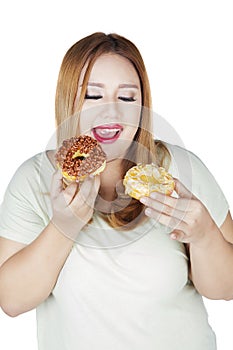 Obese woman holds two donuts