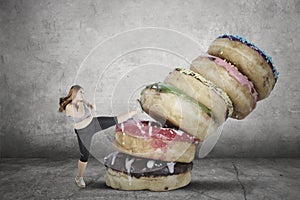 Obese woman kicking delicious donuts