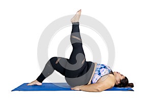 Obese woman lifting her leg during yoga exercises