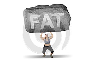 Obese woman lifting stone with fat word