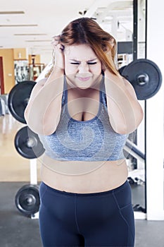 Obese woman looks depressed in the fitness center