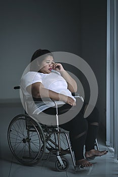 Obese woman looks sad in the wheelchair