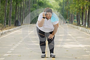 Obese woman looks tired after running