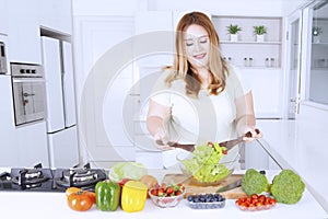 Obese woman making healthy salad