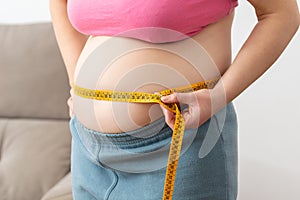 Obese woman measuring her waist