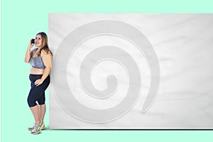 Obese woman with phone and blank banner