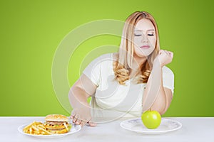 Obese woman refusing junk foods on table