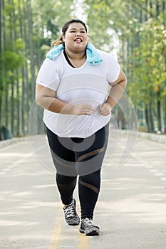 Obese woman running on the road