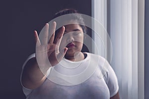 Obese woman showing hand gesture to stop