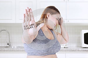 Obese woman shows eat less sugar text