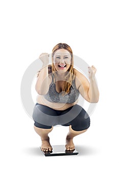 Obese woman squat down on the weight scales