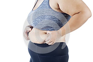 Obese woman squeezing her belly on studio