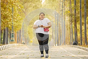 Obese woman standing on road at autumn time