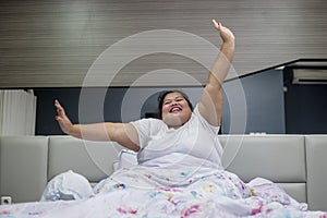 Obese woman stretching hands after wake up