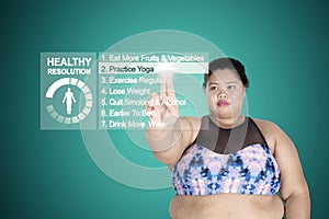 Obese woman touching practice yoga button