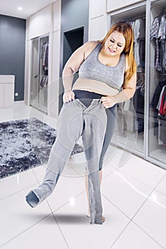 Obese woman trying to wear small jeans