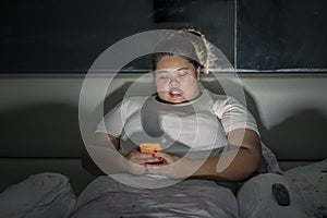 Obese woman using a mobile phone before sleep