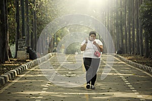 Obese woman is using a phone on the road