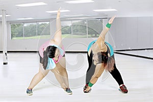 Obese women doing stretching at gym