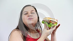 Obese women are happy with eating hamburgers. Fat girl, junk food and smiles.