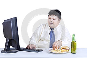 Obesity businessman working while eating