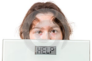 Obesity concept. Overweight woman holds scales with help written