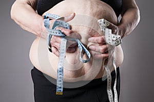 Obesity female body, fat woman with measuring tape