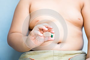 Obesity pill in fat hand