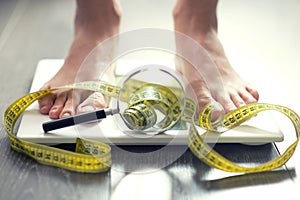 Obesity or take care of your diet and weight concept with scale and magnifying tool