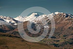 Obeso town with the snowy mountains around it photo