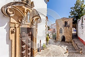 Obidos, Portugal. Misericordia Church portal and the Medieval Sephardic Synagogue in background