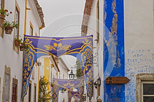 OBIDOS, PORTUGAL - 08-09-2020 : Souvenir shops and colorful narrow streets of the medieval portuguese city of Ãâbidos, a tourist