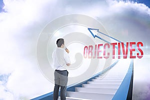 Objectives against red staircase arrow pointing up against sky