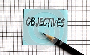 OBJECTIVES , the phrase is written on colored stickers, on a notepad background. Business concept