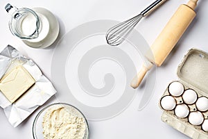 Objects and ingredients for baking, plastic molds for cookies on a white background. Flour, eggs, rolling pin, whisk