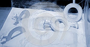 Objects printed 3D printer from powdered polyamide lying white polyamide powder