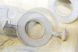 Objects printed 3D printer from powdered polyamide lying white polyamide powder