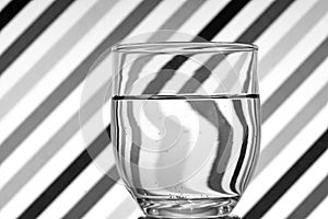 Oblique black and white lines reflected in a glass of water photo