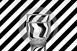 Oblique black and white lines reflected in a glass of water photo