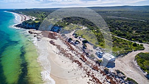 Oblique Landscape aerial view of 4WD and modern caravan parked adjacent to a sparkling sunny beach photo