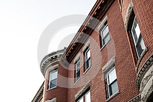 Oblique view of brick apartment building with rusticated stone window lintels and dentil trim details