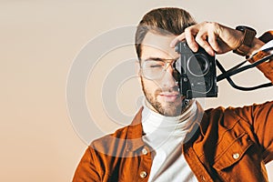 obscured view of handsome man taking picture on photo camera