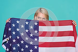 obscured view of woman with american flag looking away on blue backdrop celebrating 4th